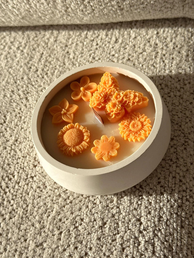 Handmade soy candle with orange flower decorations in a white ceramic bowl, Scandinavian home decor