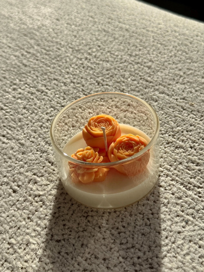 Handmade soy candle with orange rose designs in glass jar, cozy home décor