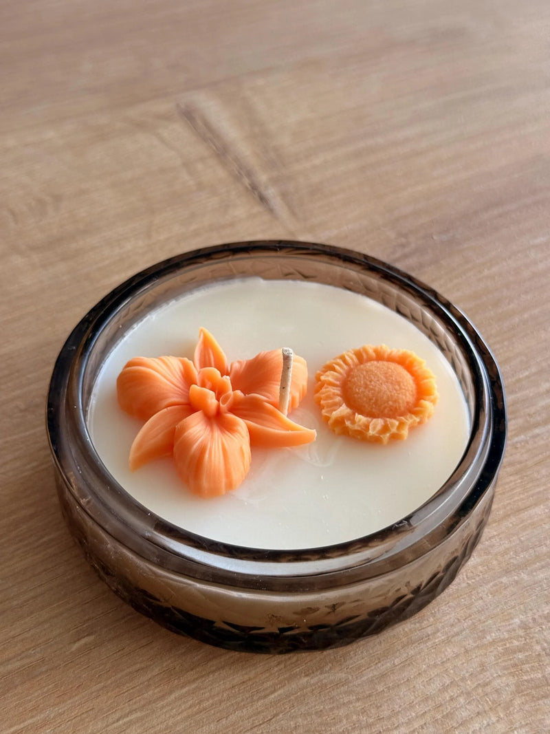 Handmade soy candle with orange flower and sunflower wax art in amber glass jar, Scandinavian home decor
