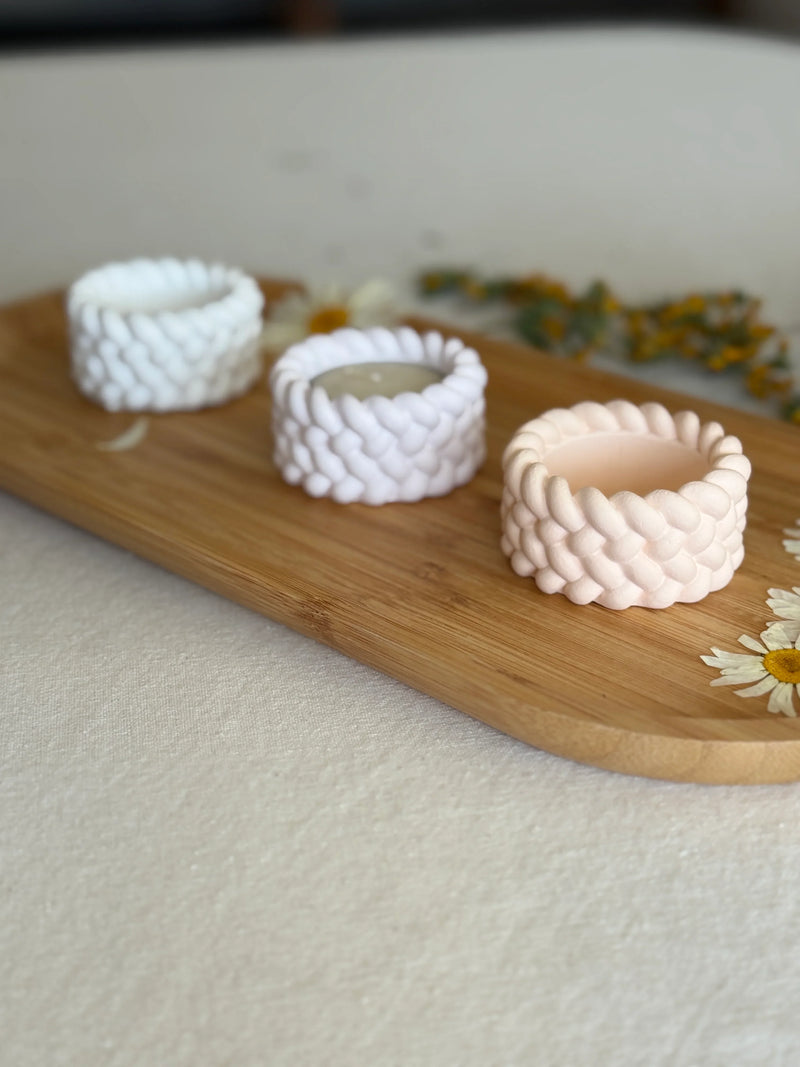 Handmade braided soy candles in white and blush, styled on a wooden tray with daisies for cozy home décor.