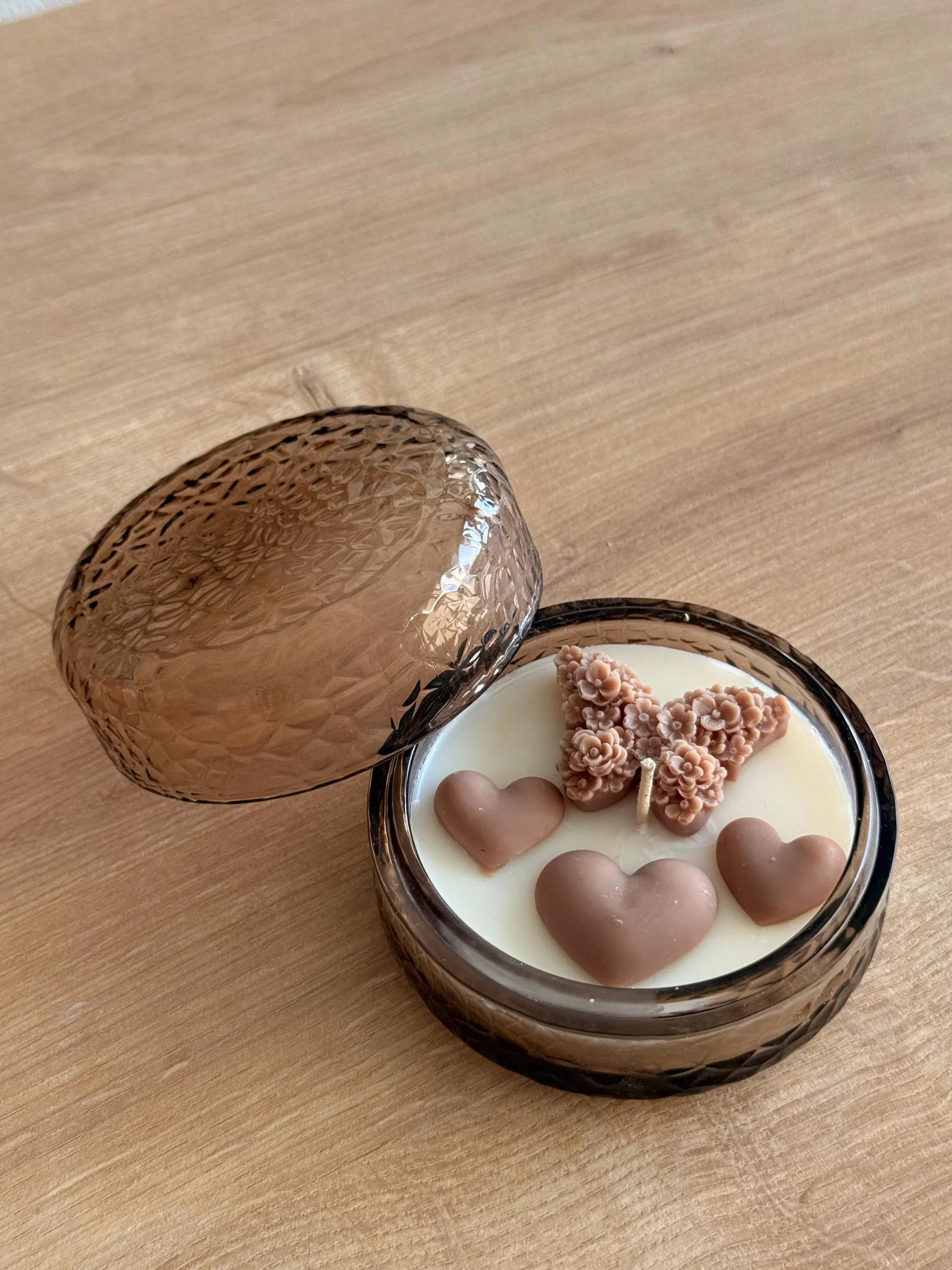 Handmade soy candle with heart and flower wax accents in amber glass jar, Scandinavian home décor