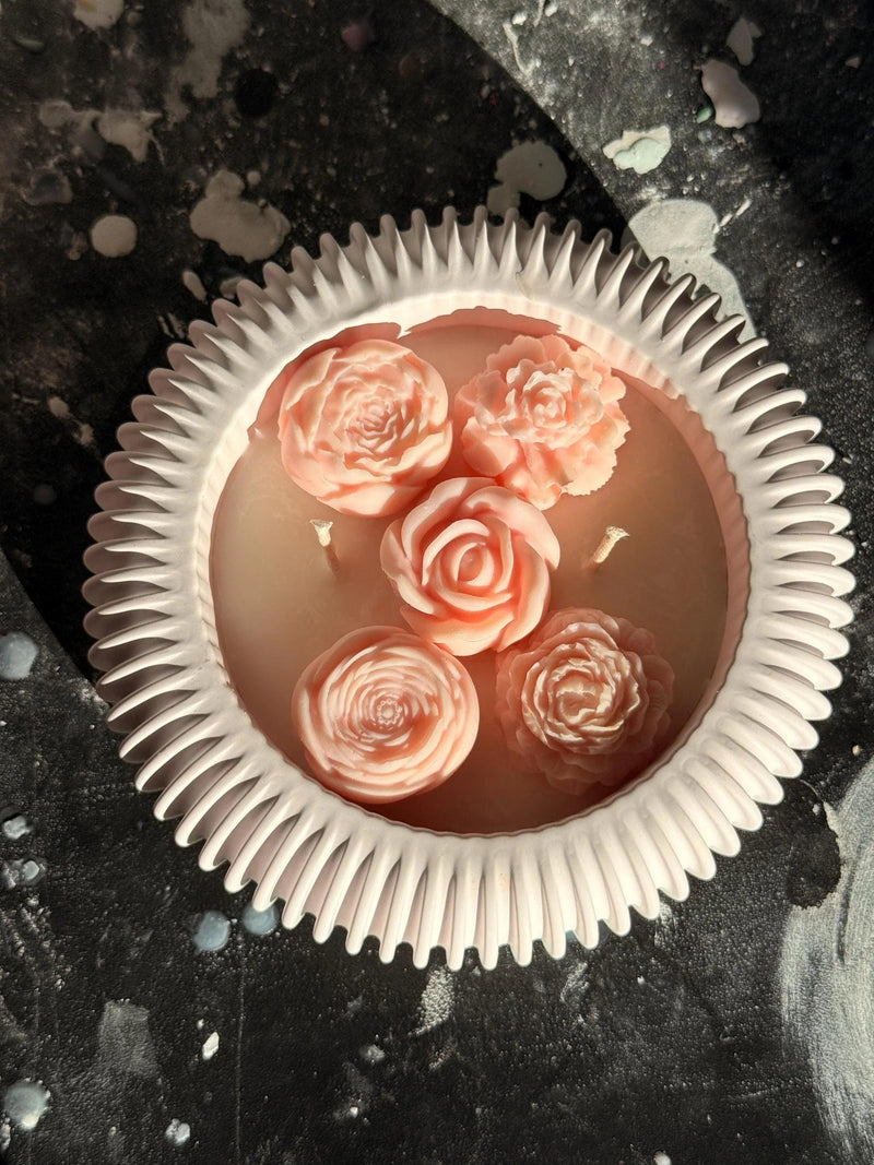 Handmade soy candle with pink rose decorations in a white ceramic dish, Scandinavian home décor