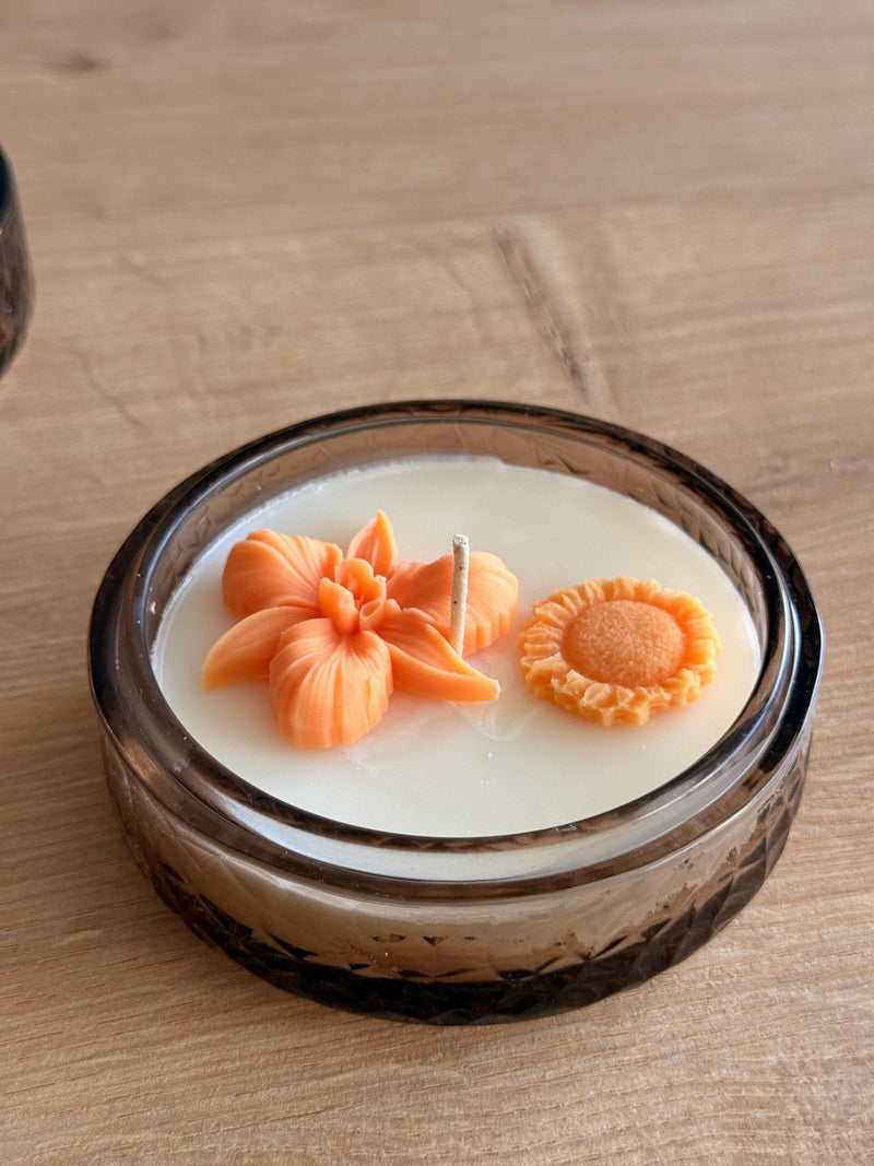 Handmade soy candle with orange flower and sun decor in amber glass jar, Scandinavian home décor