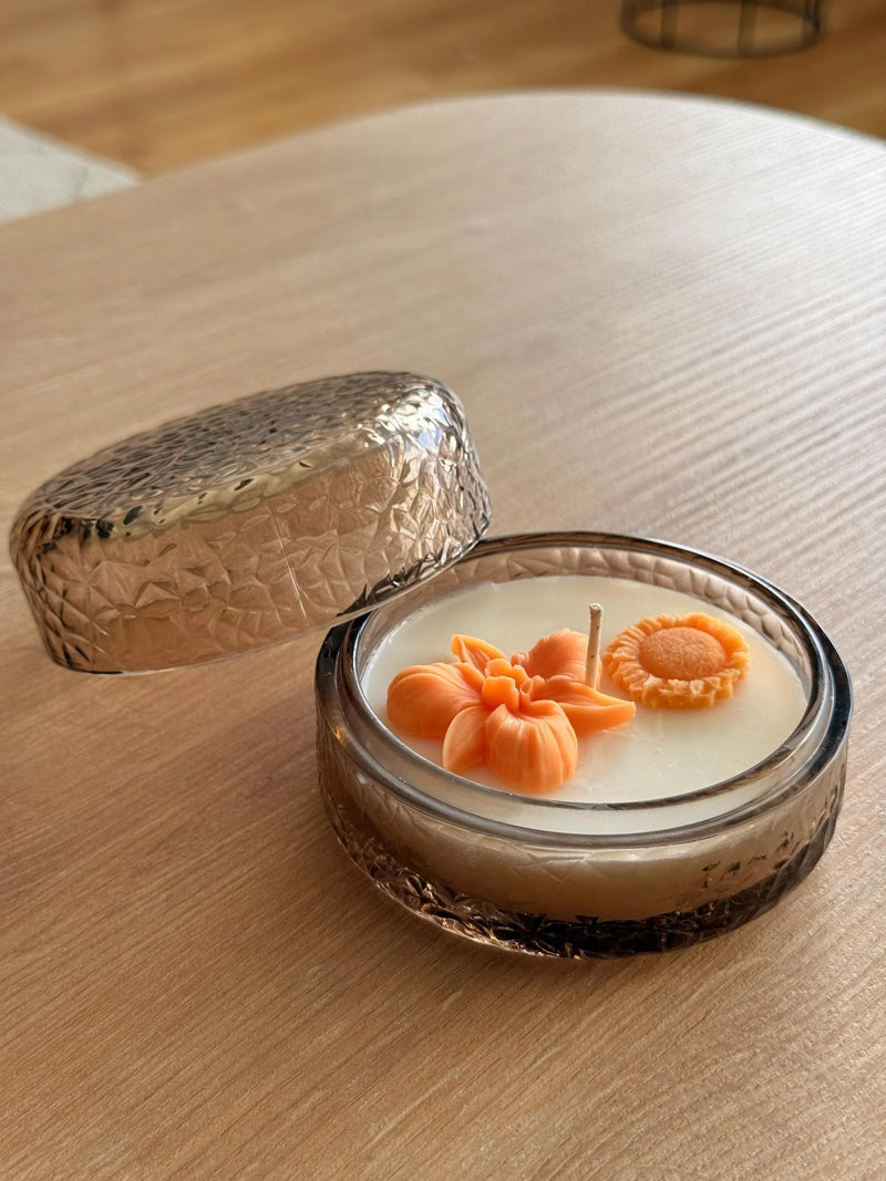 Handmade soy candle with orange flower decor in textured glass jar, Scandinavian home décor