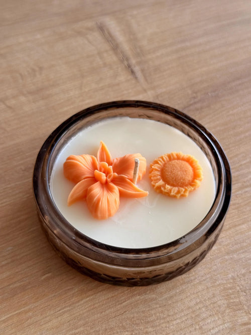 Handmade soy candle with orange flower and sun decor in amber glass jar, Scandinavian home décor