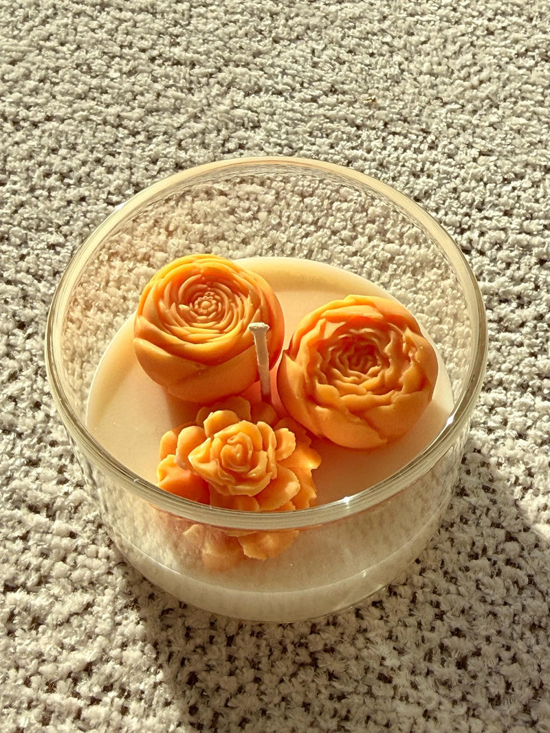 Handmade soy candle with orange rose designs in clear glass jar, cozy home décor