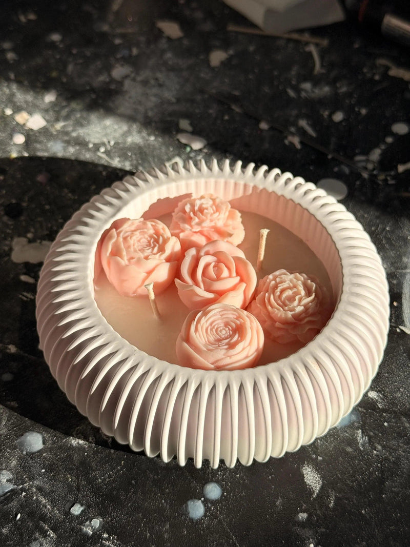 Handmade soy candle with pink rose blooms in a ribbed white ceramic dish, Scandinavian home décor