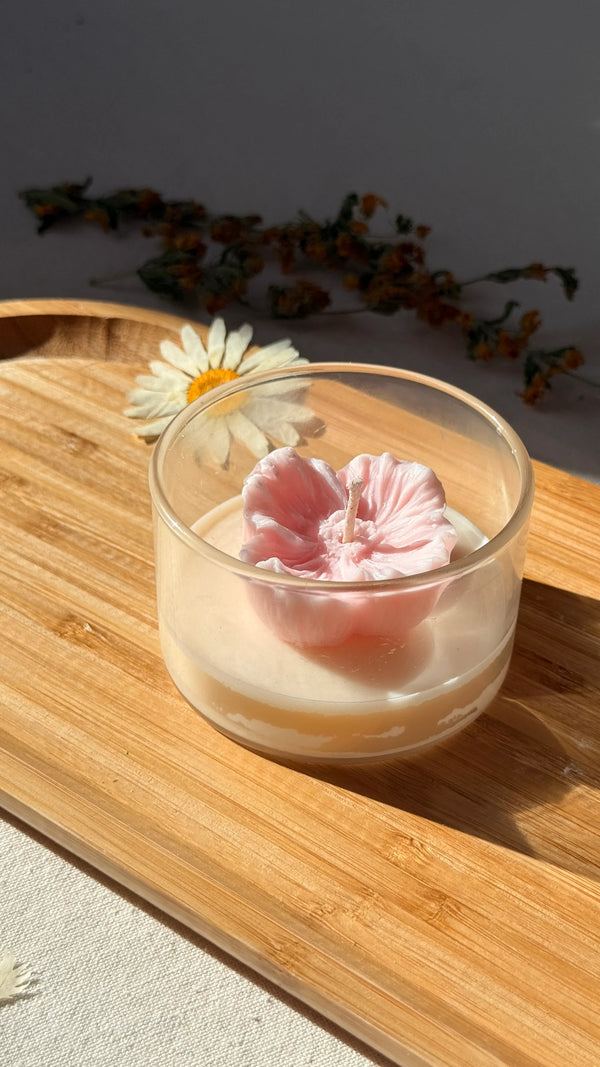 Handmade soy candle with pink flower design in glass jar, perfect for cozy home décor and thoughtful gifts.