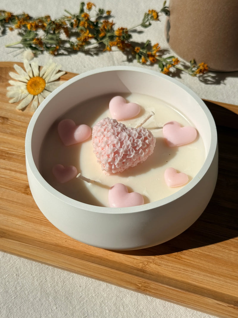 Handmade soy candle with pink heart embeds in white ceramic bowl, Scandinavian home decor