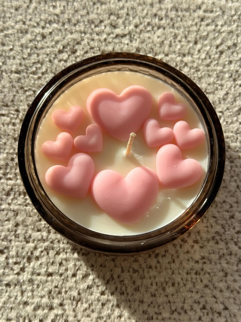 Handmade soy candle with pink heart decorations, cozy Scandinavian home décor