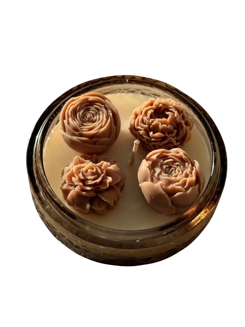 Handmade soy candle with four sculpted rose blooms in amber glass jar, Scandinavian home décor