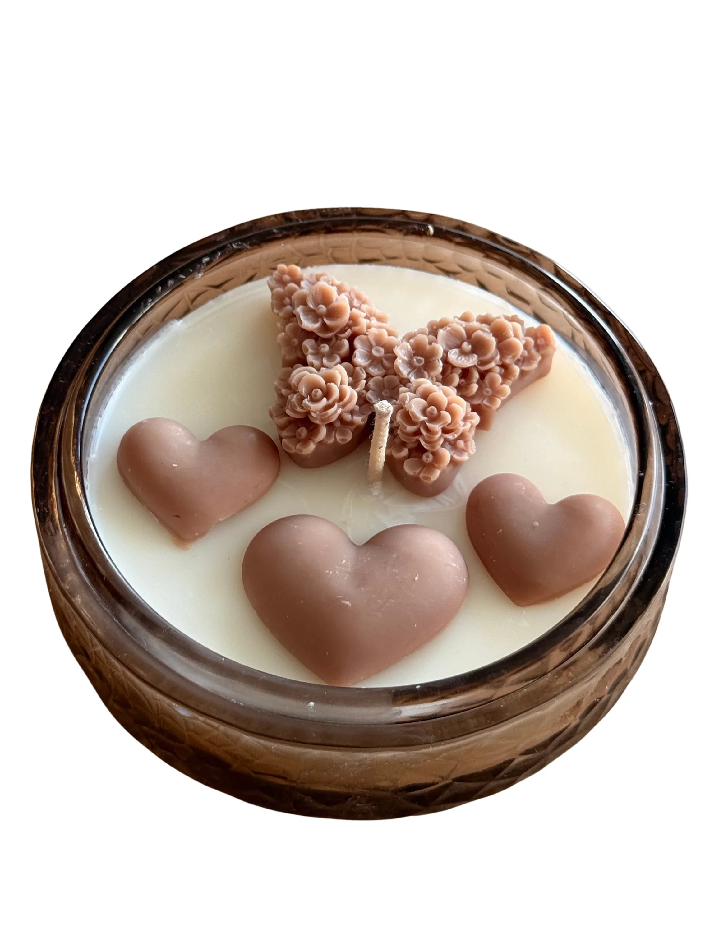 Handmade soy candle with floral butterfly and heart wax accents in amber glass jar