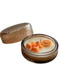 Handmade soy candle with orange flower decor in textured glass jar, Scandinavian home décor