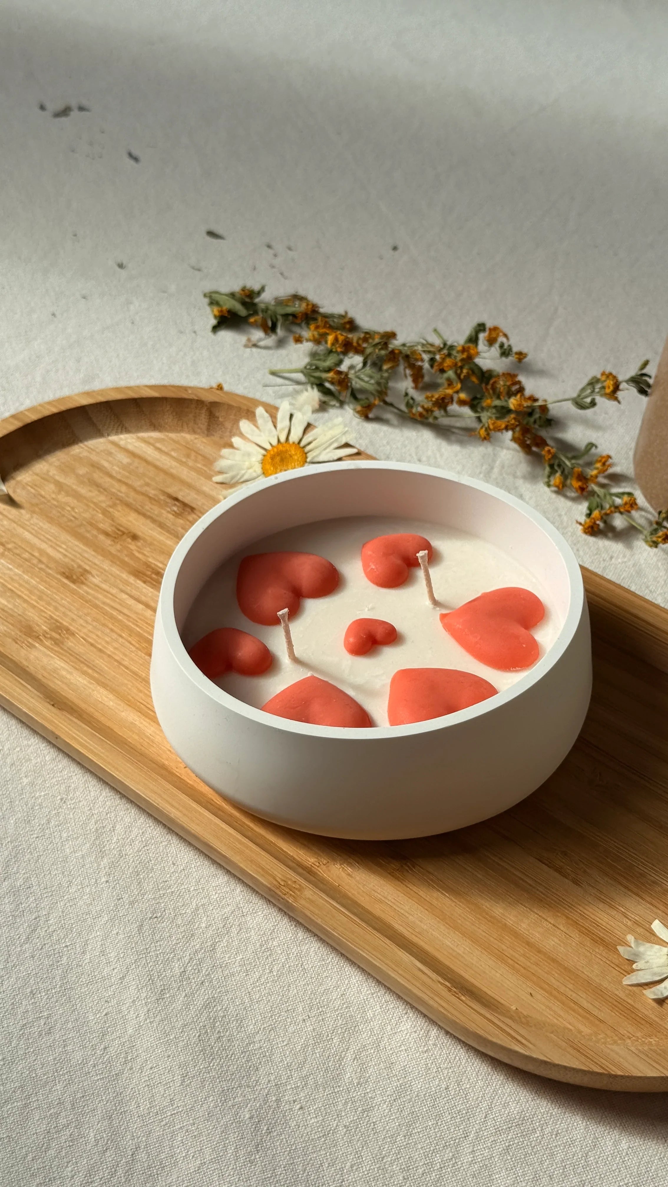 Handmade soy candle with coral hearts in white bowl, Scandinavian home decor on wooden tray