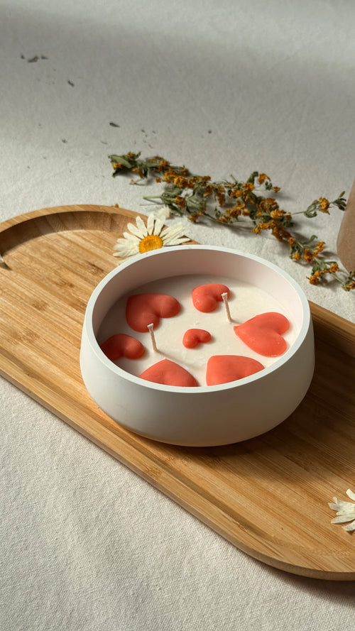 Handmade soy candle with coral hearts in white bowl, Scandinavian home decor on wooden tray