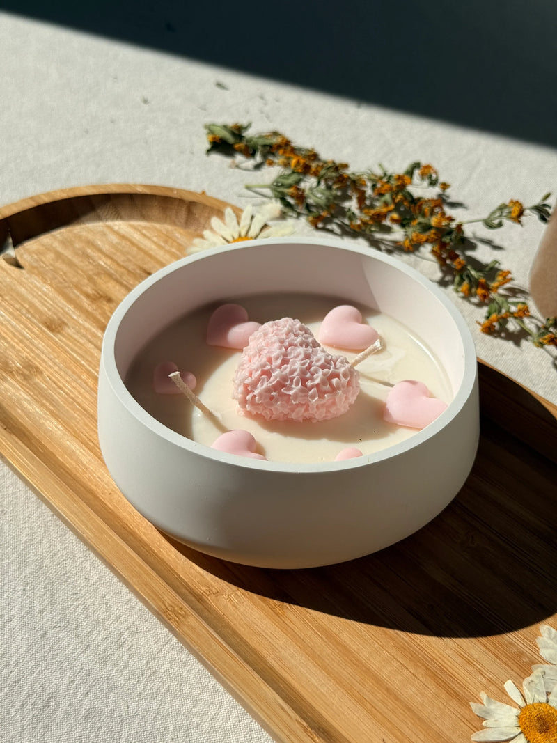 Handmade soy candle with pink heart wax melts in white bowl on wooden tray, Scandinavian home decor