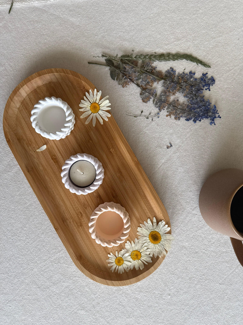 Handmade ceramic tea light holders with rope design on wooden tray, styled with daisies and dried lavender for cozy Scandinavian home decor