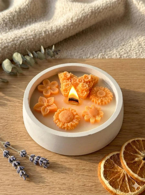 Handmade soy candle with orange flower wax melts, lavender, and dried orange slices on wood — cozy Scandinavian home décor