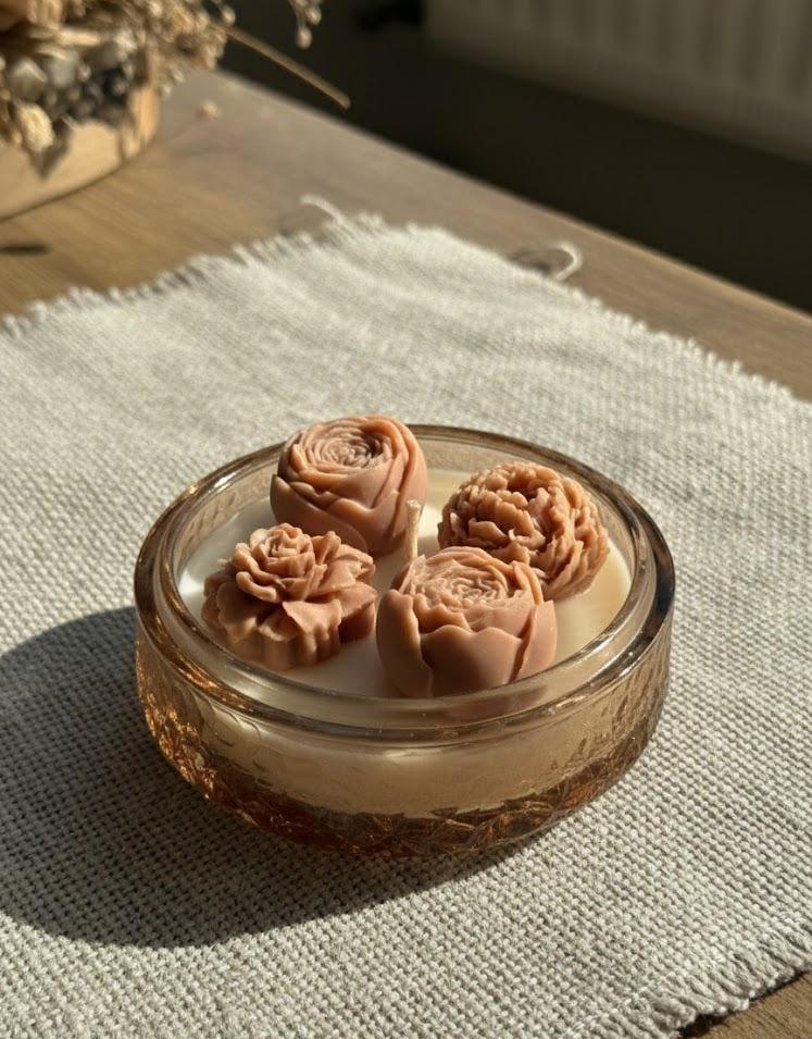 Handmade soy candle with rose-shaped wax blooms in amber glass, Scandinavian home decor