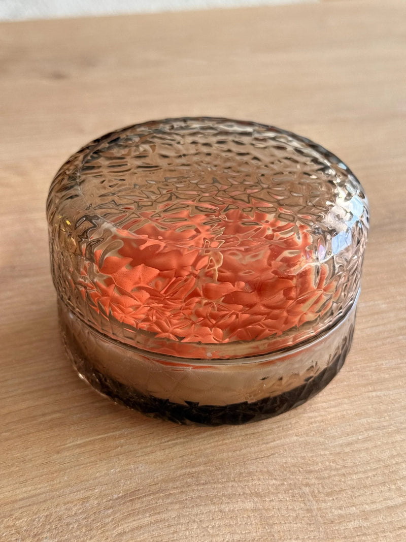 Handmade soy candle in textured glass jar with orange floral design, Scandinavian home décor