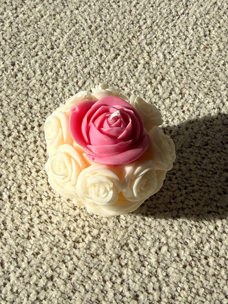 Handmade soy candle shaped like a pink rose with white petals, perfect for cozy home décor or thoughtful gifts.