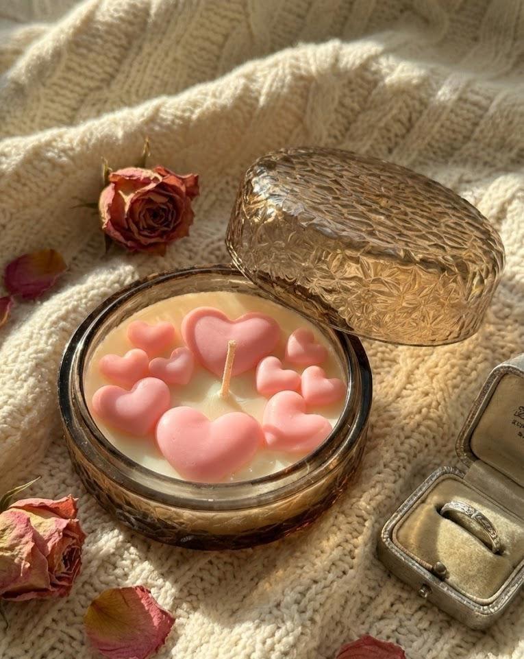 Pink heart-shaped soy candle in glass jar with dried roses, cozy Scandinavian home décor