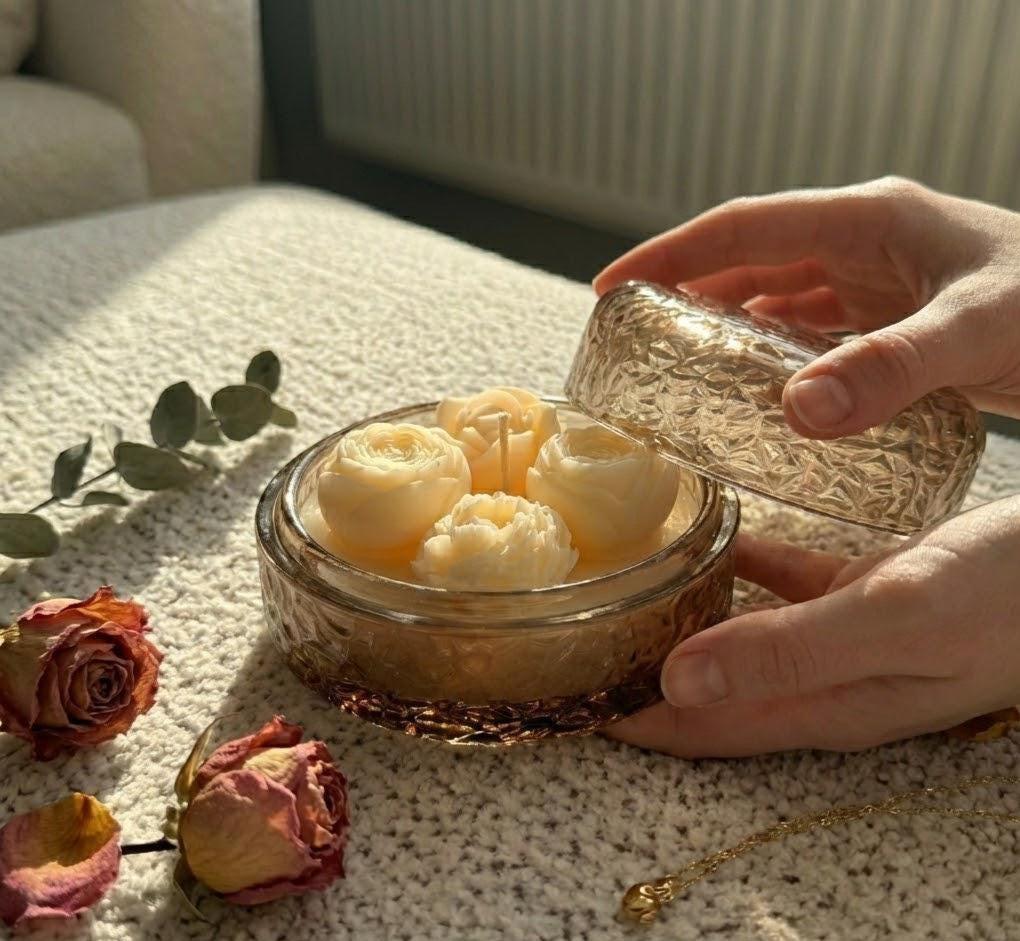 Handmade soy candle with rose-shaped wax blooms in amber glass jar, Scandinavian home decor