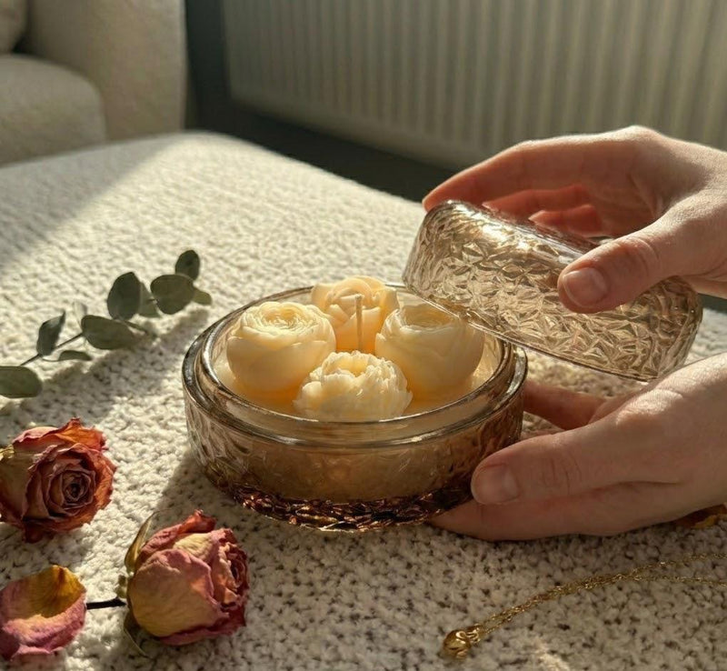 Handmade soy candle with rose-shaped wax blooms in amber glass jar, Scandinavian home decor