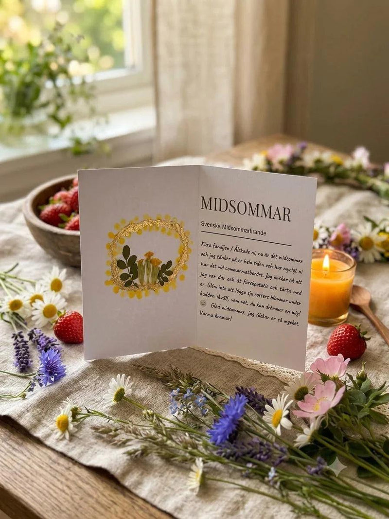 Scandinavian midsummer card with wildflowers, lit soy candle, and fresh strawberries on rustic table