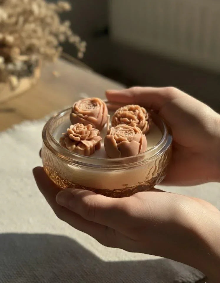 Hands holding a glass soy candle with rose-shaped wax blooms, perfect for cozy Scandinavian home décor.
