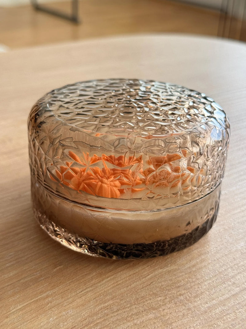 Handmade soy candle in textured glass jar with orange floral design, Scandinavian home decor